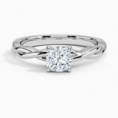 a white gold ring with an oval cut diamond in the center and twisted band around it