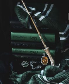 a harry potter book and wand sitting on top of green blankets next to each other