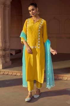 Yellow three fourth sleeves A-line kurta with buttercup bloom embroidery on the yoke using white toned beads, cut dana, sequins highlights. Paired with a matching straight pant and scallop border sky blue dupatta. - Aza Fashions Light Blue Indian Outfit, Festive Yellow Embellished Kurta, Yellow Sets With Gota Work For Spring, Spring Yellow Sets With Gota Work, Embellished Yellow Sets For Spring, Spring Embellished Yellow Sets, Yellow Traditional Wear With Dabka Work For Spring, Yellow Indian Dress, Blue Indian Outfit