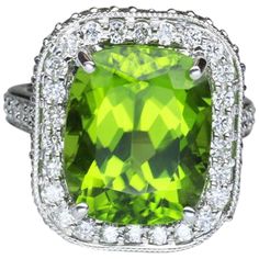 Elegant & finely detailed Ring, center set with a securely nestled 11.29 Cushion Cut Green Peridot, 14.0mm x 11.5mm; clarity internally flawless (IF), no treatment; surrounded by and enhanced on shank with micro-set Brilliant full cut Diamonds, weighing approx. 1.95 total carat weight; color: E/F; clarity: VS; Hand crafted in 18 Karat white Gold. The ring epitomizes vintage charm and would make a lovely alternative engagement ring. The ring is in excellent condition and was recently professional Cushion Cut Engagement, Statement Rings Diamond, Oval Cut Engagement Ring, Moonstone Engagement, Cushion Cut Engagement Ring, Gold Diamond Wedding Band, Gold Statement Ring, Moonstone Engagement Ring, Three Stone Diamond