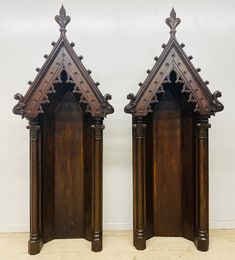 pair of antique wooden clock faces with ornate carvings on the front and back, in dark wood