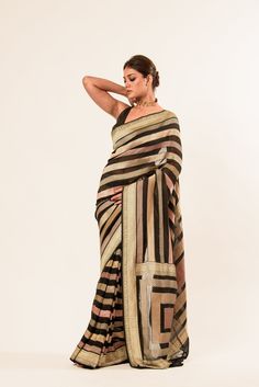 The pure khaddi georgette saree in Black, a timeless and elegant piece. With its striped body and a dull gold zari border, this handwoven Banarasi masterpiece exudes sophistication. Elegant Black Saree With Border, Striped Saree, Khaddi Georgette Saree, Baluchari Saree, Saree In Black, White Embroidered Blouse, Silver Blouse, Net Blouses, Cotton Gowns