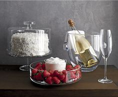 there is a cake and two wine glasses sitting on the table next to each other