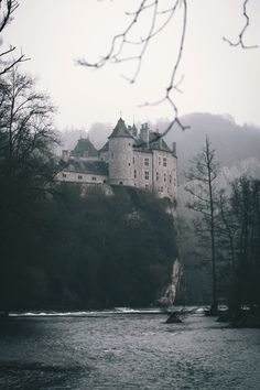 a castle sitting on top of a hill next to a river