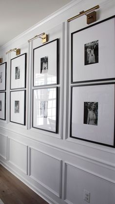 a wall with many pictures hanging on it's sides and framed photos above them