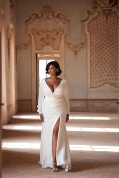 a woman in a white dress posing for the camera