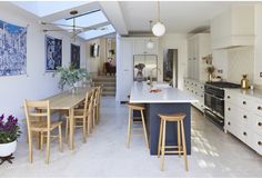 a large kitchen with an island counter top and wooden stools in front of it