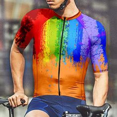 a man riding a bike wearing a colorful shirt and helmet with the colors of the rainbow painted on it