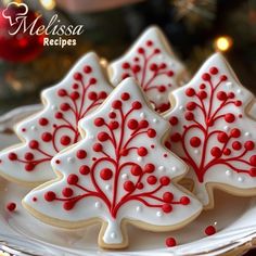 three decorated christmas trees on a plate with red and white sprinkled icing