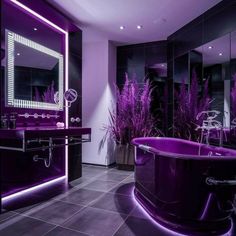 a bathroom with purple lighting and an oval bathtub in the middle of the room