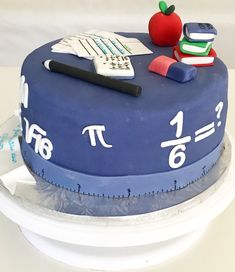 a cake that has some books and an apple on it with a calculator