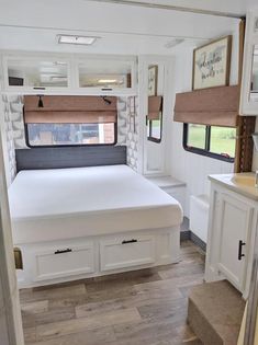 the interior of a camper with a bed, sink and window in front of it