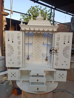 a white cabinet sitting on top of a table next to other furniture and decor items