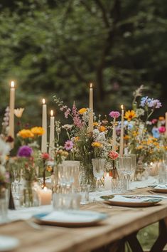 wedding table decorated with taper candles and wildflowers Wedding Dining Tables, Garden Whimsy Wedding, Wildflower Long Table Wedding, Wild Flower Decorations Wedding, Whimsical Garden Wedding Flowers, Wildflower Winter Wedding, Whimsical Garden Wedding Table Decor, Whimsical Wedding Tables, Garden Party Wedding Tablescape