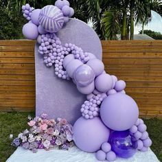 a large purple balloon sculpture sitting on top of a lush green field