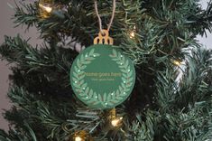 a green ornament hanging from a christmas tree