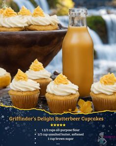 cupcakes with frosting next to a bottle of orange juice