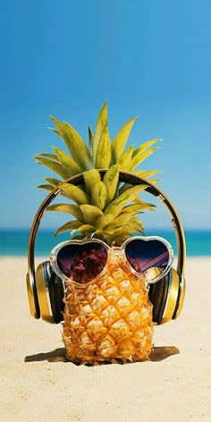 a pineapple wearing sunglasses and headphones on the beach