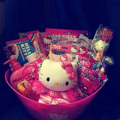 a pink hello kitty gift basket filled with candy, candies and other items in it