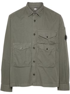 olive green cotton gabardine weave classic collar long sleeves signature Lens detail buttoned-cuff sleeves three front flap pockets straight hem front button fastening C.P. Company suggests removing any detachable accessories before washing. Comme Des Garcons Converse, Buttoned Shirt, Jumpsuit Jacket, C P Company, Airport Fashion, Balenciaga Triple S, Stella Mccartney Adidas, Summer Beach Wear, Mens Outerwear