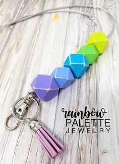 a keychain made out of wooden blocks with tassels on it and the words rainbow pastele jewelry