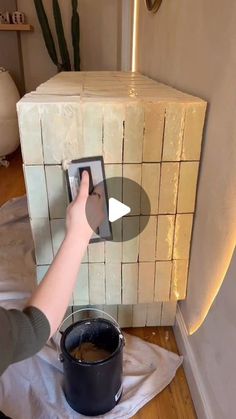 a person using a bucket to clean a tiled wall