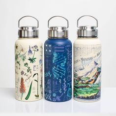 three water bottles with designs on them sitting next to each other