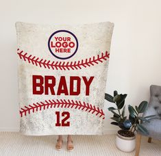 a woman is holding up a baseball towel