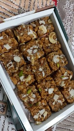 a box filled with granola and nuts on top of a table next to utensils