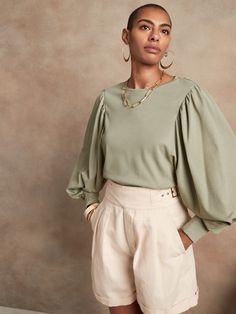 Made to turn heads, this 100% cotton top features long, exaggerated sleeves with soft pleating at the shoulder.  Pair it with your favorite denims or tucked into a silky pleated skirt for added splendor.  FITTED: Stretches to fit.  Crew neck.  Balloo Workwear Long Sleeve Blouse With Elastic Shoulders, Chic Billowy Cotton Blouse, Chic Cotton Puff Sleeve Top For Daywear, Billowy Chic Cotton Blouse, Spring Cotton Puff Sleeve Top For Workwear, Chic Puff Sleeve Top With Elastic Shoulders For Work, Fall Long Sleeve Blouse With Elastic Shoulders, Fall Tops With Balloon Sleeves And Elastic Shoulders, Fall Tops With Elastic Shoulders And Balloon Sleeves