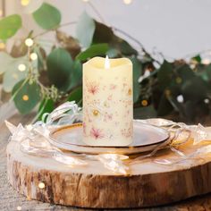 a lit candle sitting on top of a wooden plate