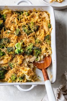 a casserole dish with broccoli and noodles in it on a table