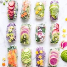 several different types of sushi on a white table with star shaped objects around them