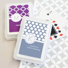 two playing cards sitting next to each other on top of a table with white and purple designs