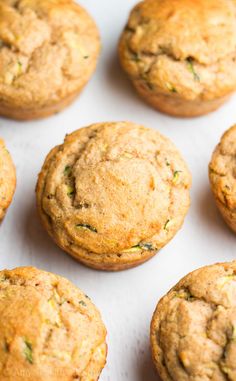 freshly baked zucchini muffins are lined up on a baking sheet, ready to be eaten