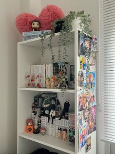 a white book shelf filled with lots of books and stuffed animals on top of it