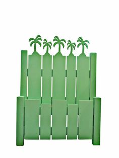 green plastic fence with four palm trees on top and one in the middle, set against a white background