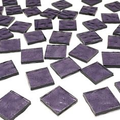 purple square tiles are scattered on a white surface