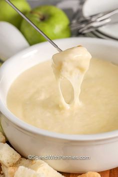 a white bowl filled with cheese and crackers on top of a wooden cutting board