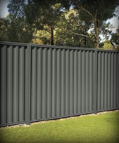 a tall metal fence sitting in the grass