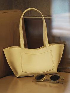 Editor's NotesThis is (GYEOL)'s shoulder bag that goes well with any outfits - Voluminous bag- Comfortable fit- Moderate item- Trendy design Measurements(in.)- Size: 7.48(W) * 5.31(H) * 4.33(D) in. Composition & Care- Artificial Leather- Avoid direct heat and moisture- Store in a well ventilated shade- Put it in a dust bag to avoid contact with other products- Be careful when wearing bright-colored leather products as they may be stained by denim or dyed fabricsDesig Chic Shoulder Bag With Pockets And Double Handle, Elegant Beige Shoulder Bag With Pockets, Chic Satchel With Pockets, Chic Shoulder Bag With Pockets For Shopping, Chic Beige Bags With Pockets, Chic Shoulder Bag With Pockets, Bright Colored, Leather Products, Colored Leather