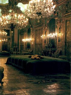 an ornately decorated bedroom with chandeliers and large bed in the center,