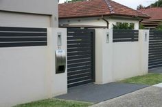 a row of black and white garage doors next to a sidewalk in front of a house