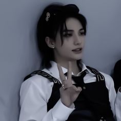 a woman in uniform making the v sign with her fingers