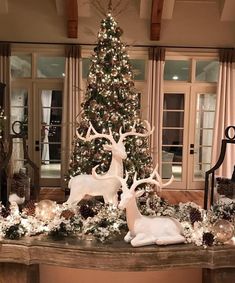 a christmas tree with white lights and deer figurines