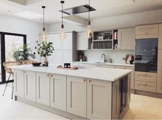 a large kitchen with an island in the middle and lots of lights hanging above it