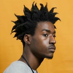 a young man with dreadlocks on his head looking off to the side in front of a yellow background