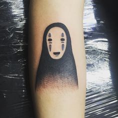 a person with a black and white tattoo on their arm that has a spirited face