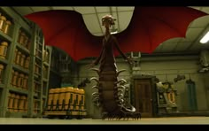 a large dragon standing in a warehouse next to shelves filled with yellow and red barrels