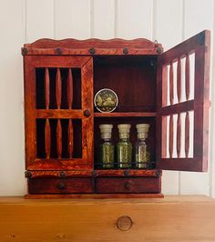 an old wooden cabinet with spice jars in it